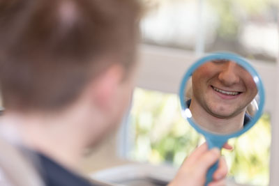 patient looking at their smile in the mirror