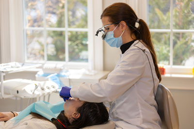 Dr. Belussi-Campos providing dental care for a patient